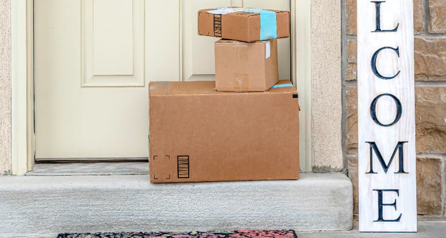 Boxes by the door of a residence with a welcome sign in Mesa